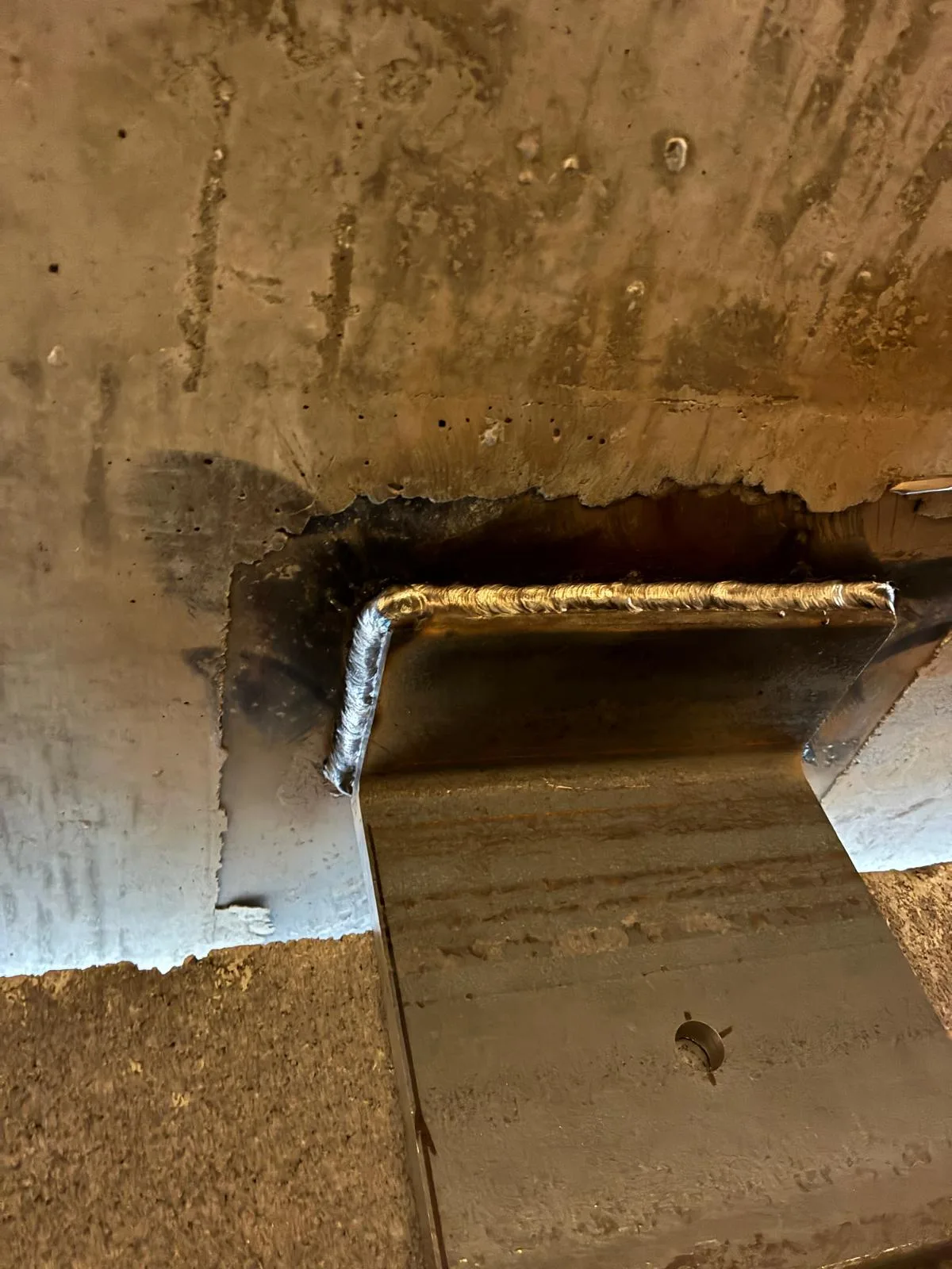 Finished structural steel weld on a support bracket